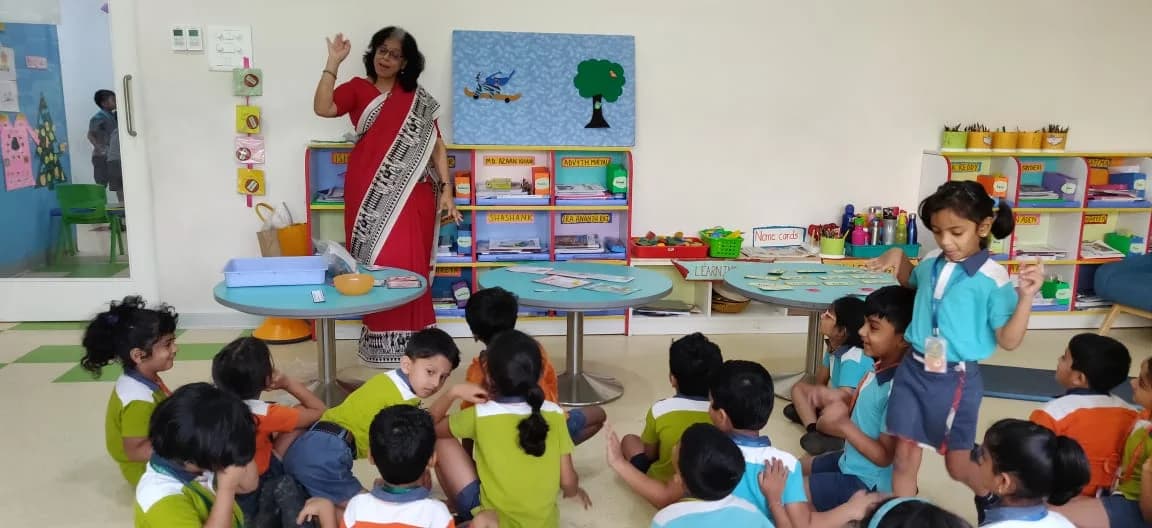 Children seated on the floor during the warm-up activity